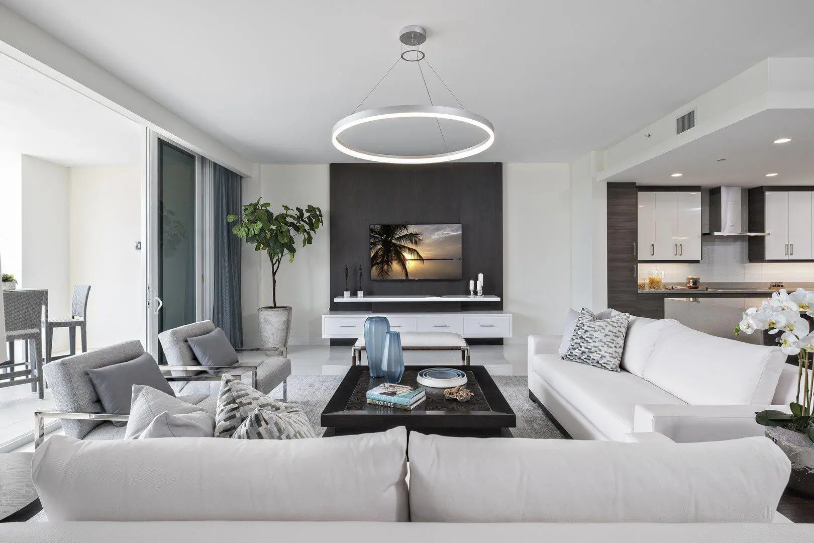 A living room with white furniture and a flat screen tv.