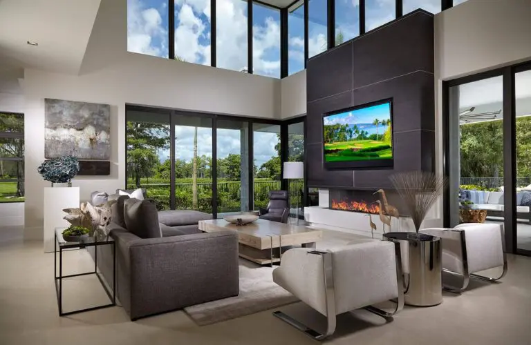 A living room with two large windows and a fireplace.