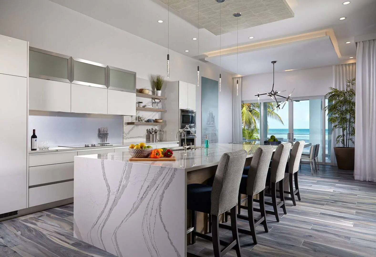A kitchen with marble counter tops and white cabinets.