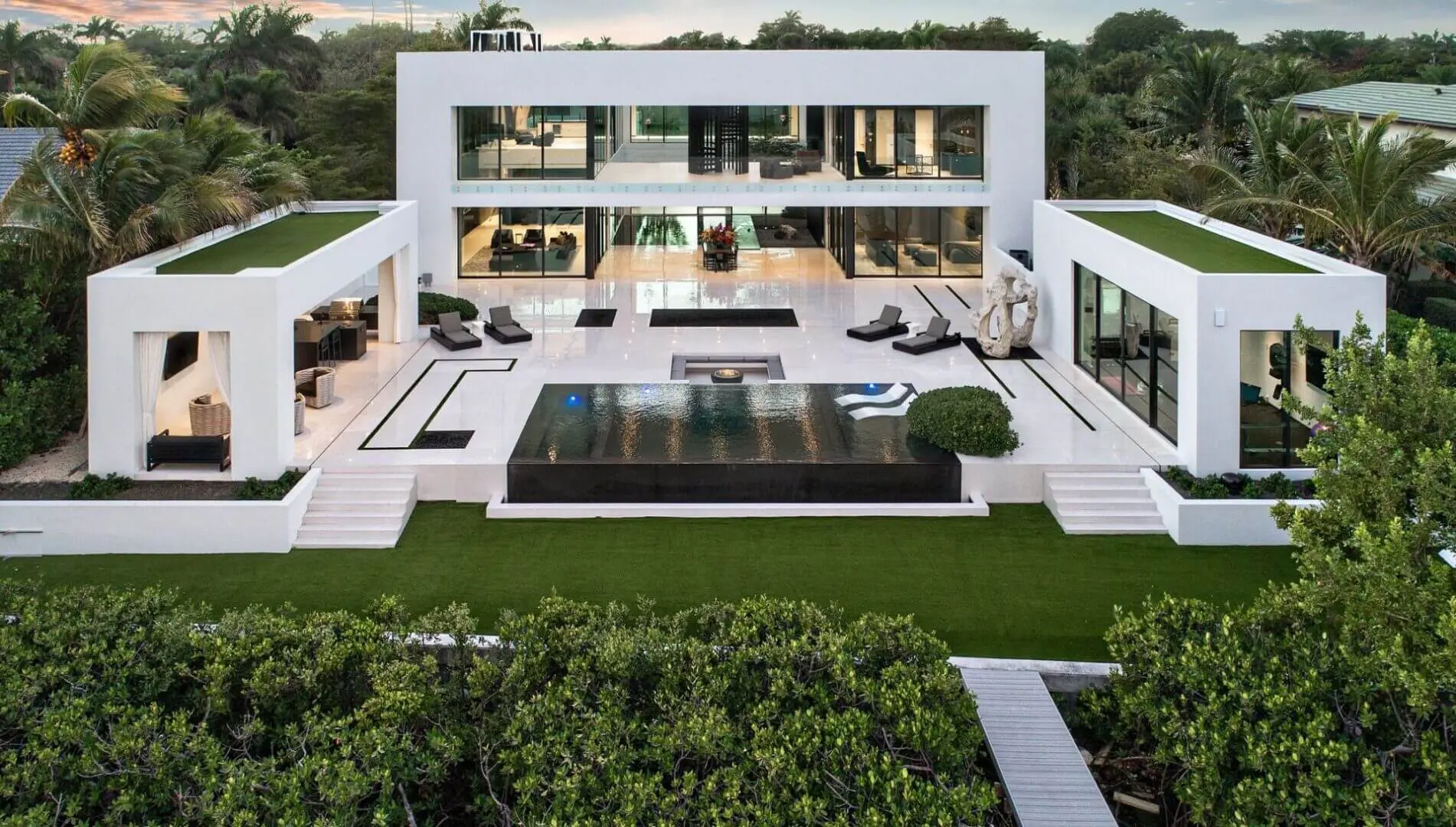 A large white house with a pool in the middle of it