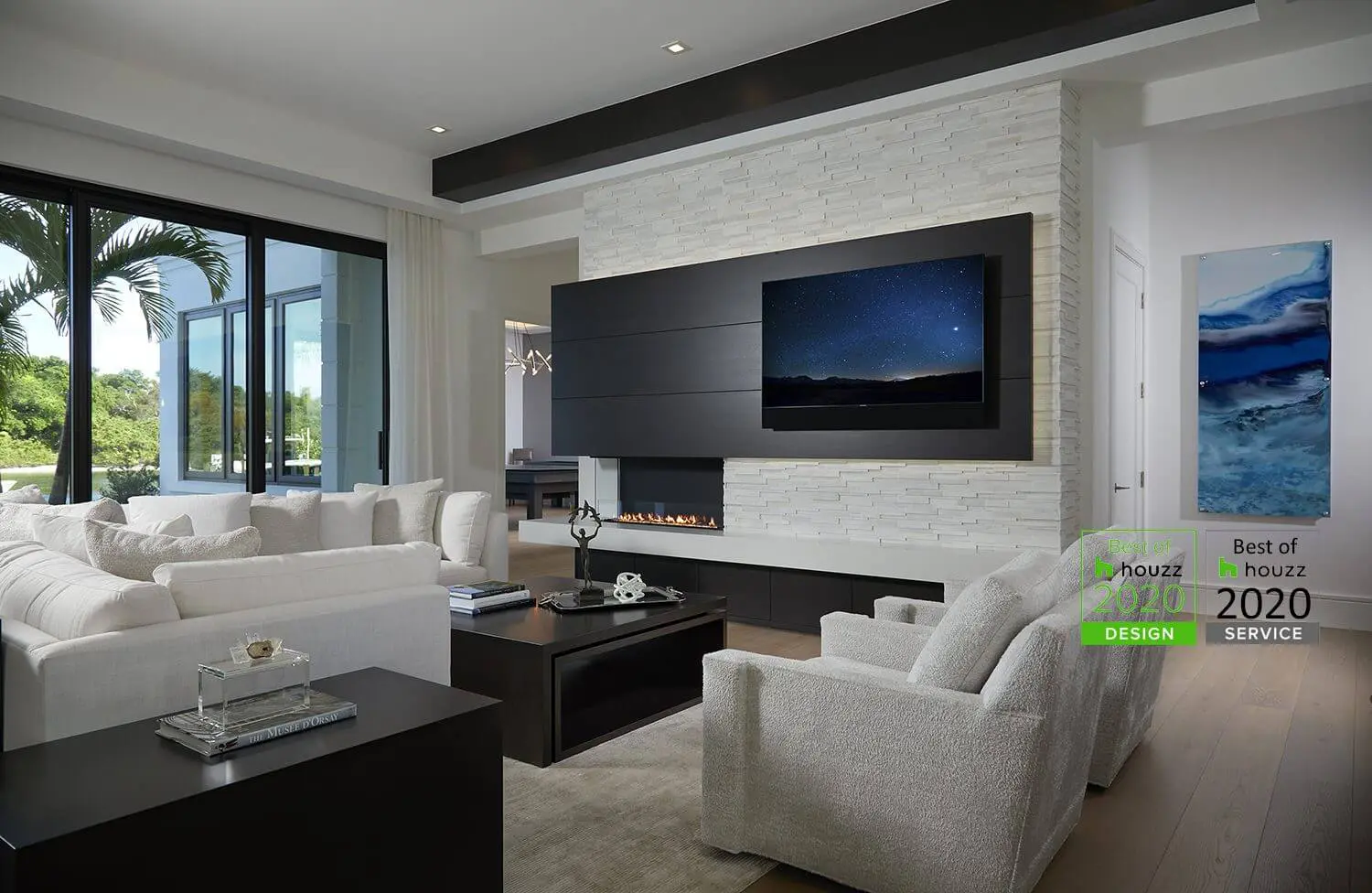 A living room with white furniture and a flat screen tv.