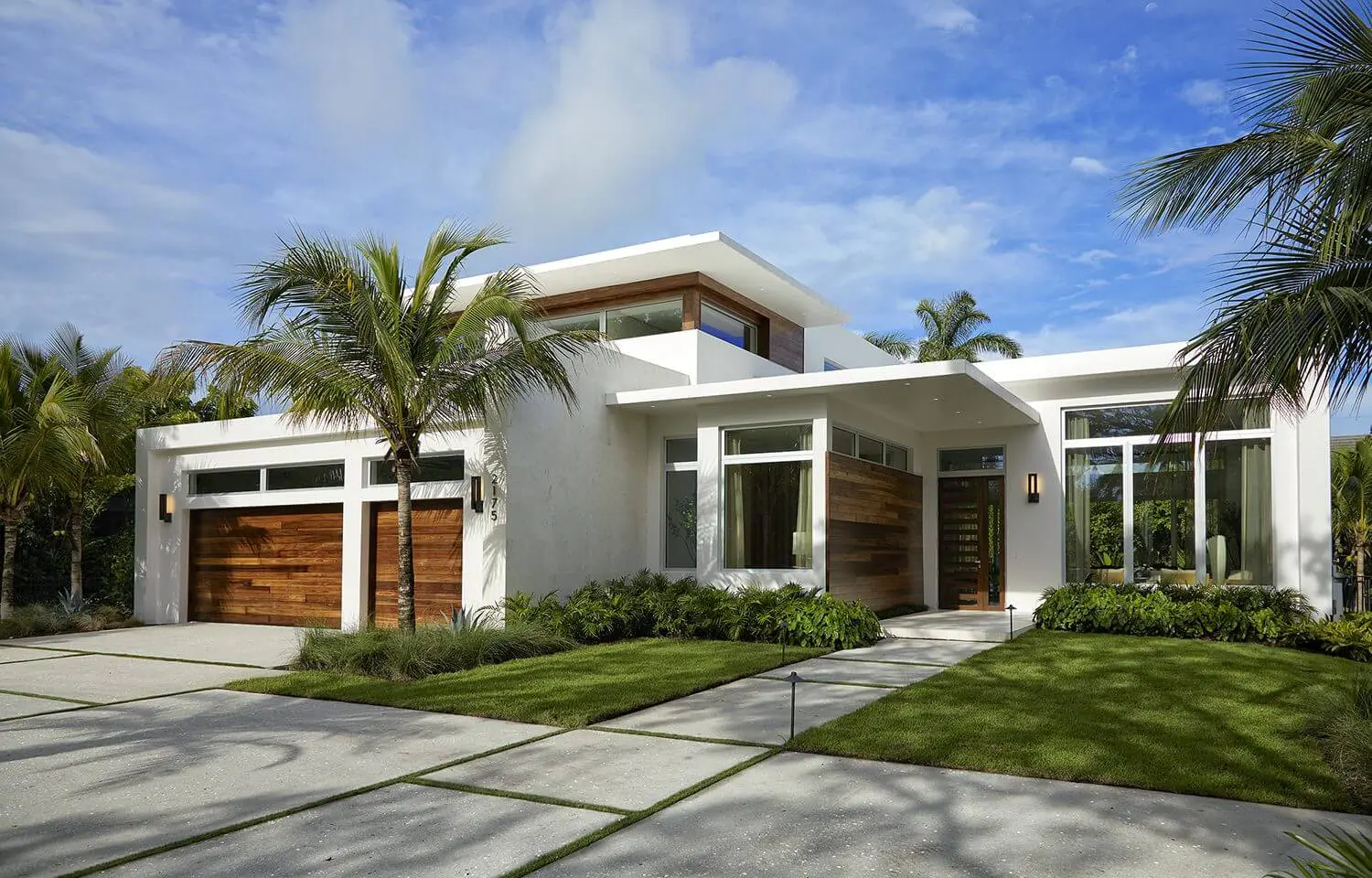 A white house with palm trees and grass