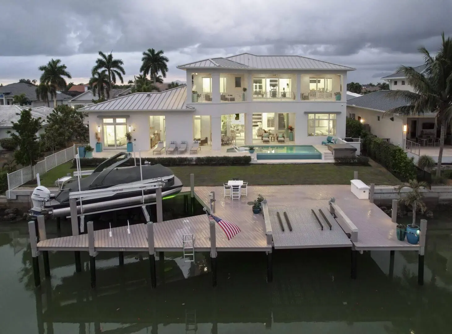A large white house with a dock in the middle of it.
