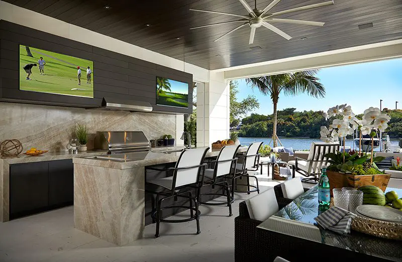 A large outdoor kitchen with an island and television.