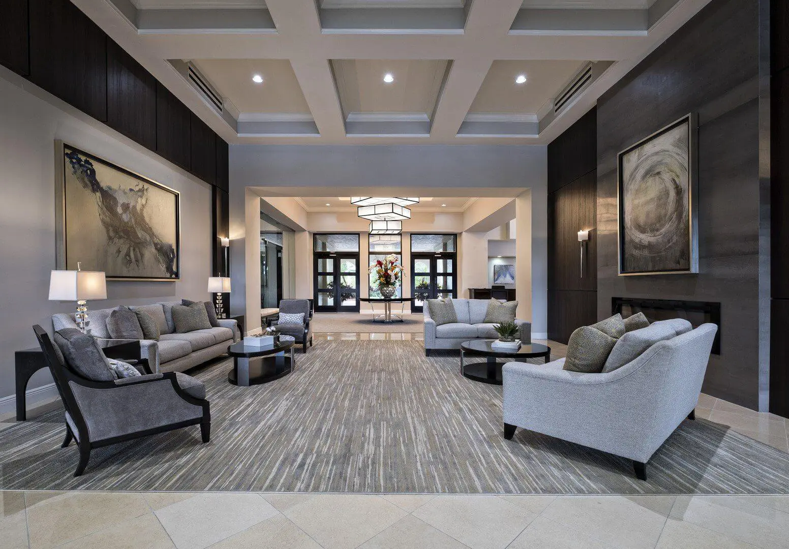 A lobby with couches, chairs and tables in it.