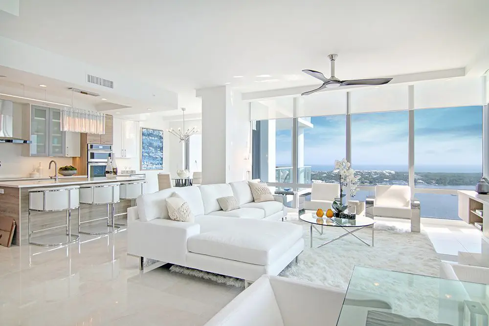 A living room filled with furniture and large windows.