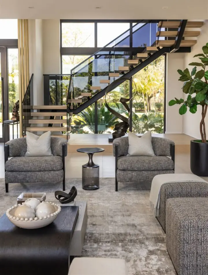 Living room filled with furniture such as sofas with cushions, a table with a bowl and other objects