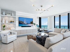 A living room with a large screen tv and white furniture.