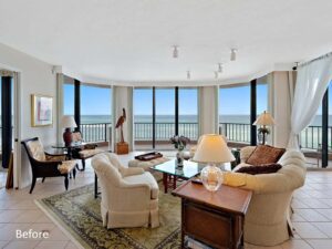 A living room with a large window and ocean view.