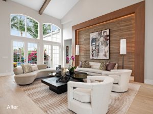 A living room with white furniture and wood paneled walls.