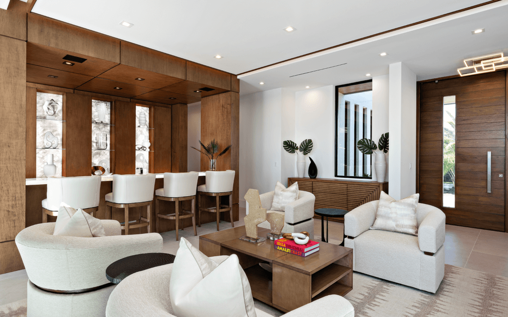 A living room with white furniture and wooden walls.