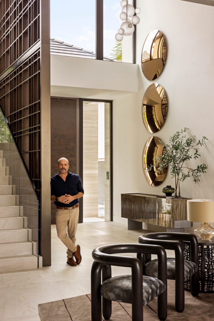 An interior designer organizing modern decor on a shelf.