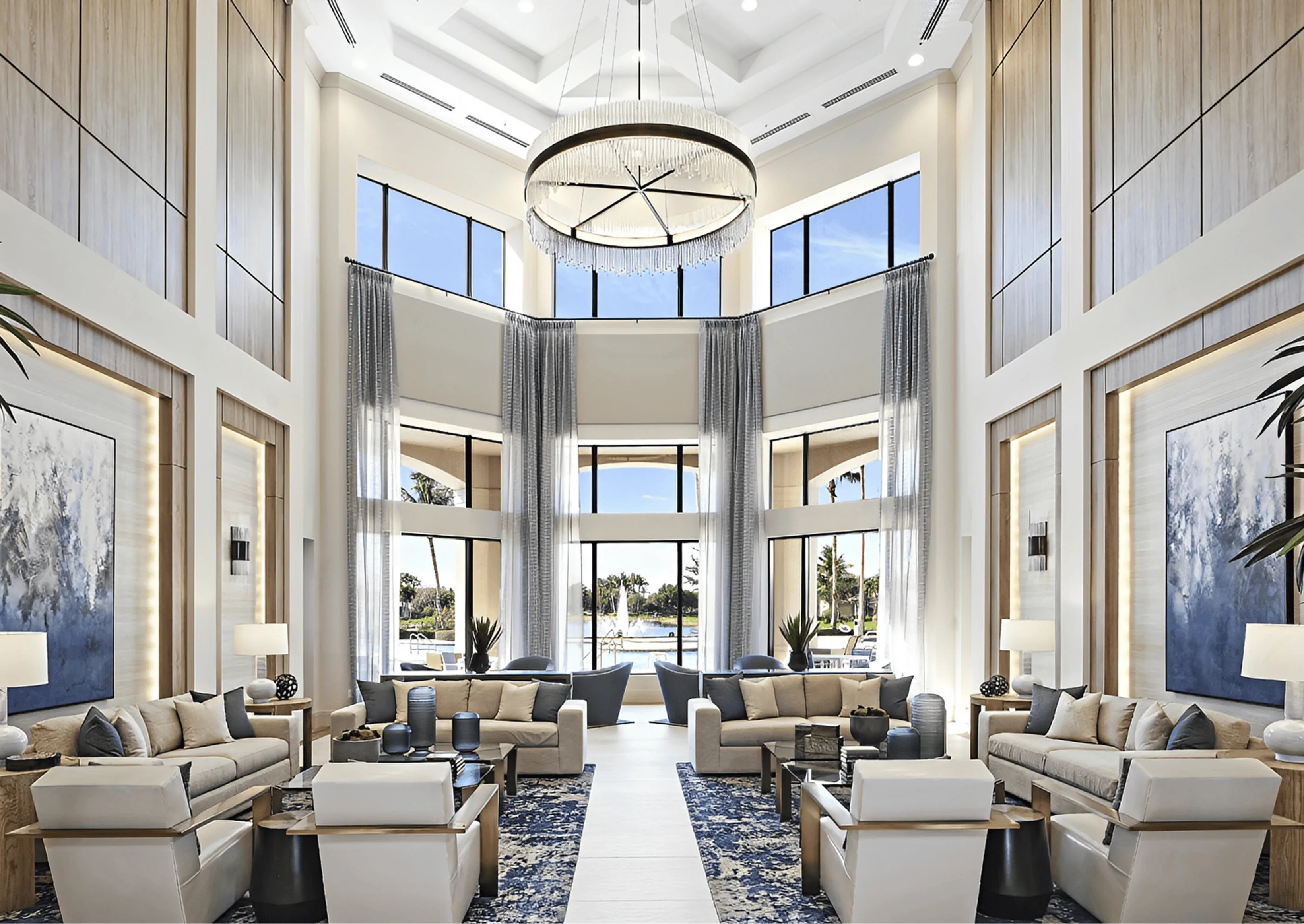 Luxurious living room with a large chandelier hanging from the ceiling, a sofa set with cushions, side tables