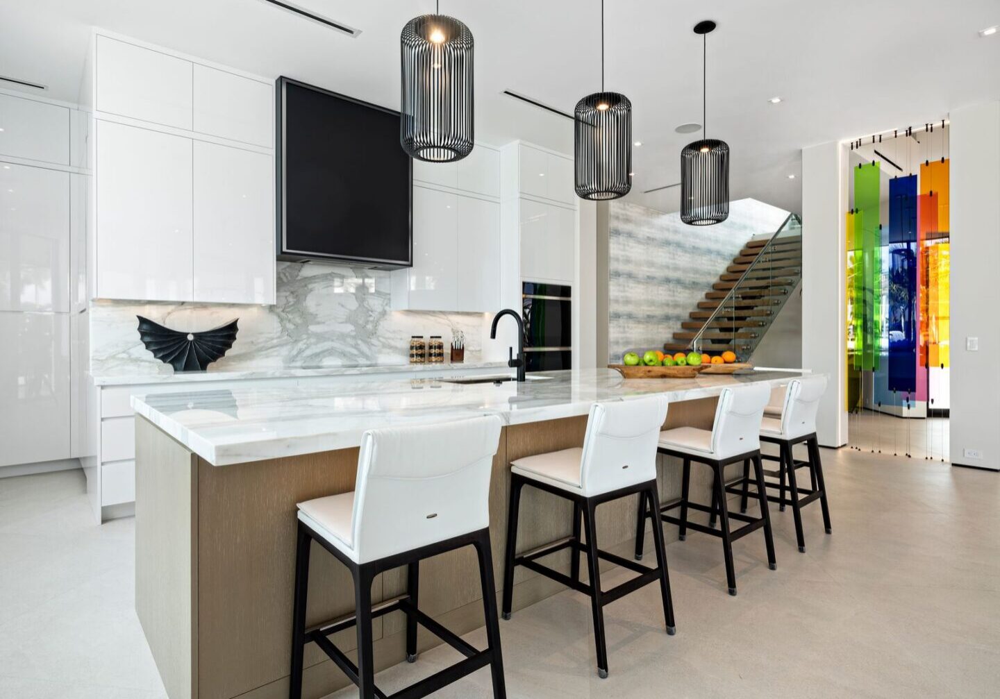 A kitchen with white cabinets and black counter tops