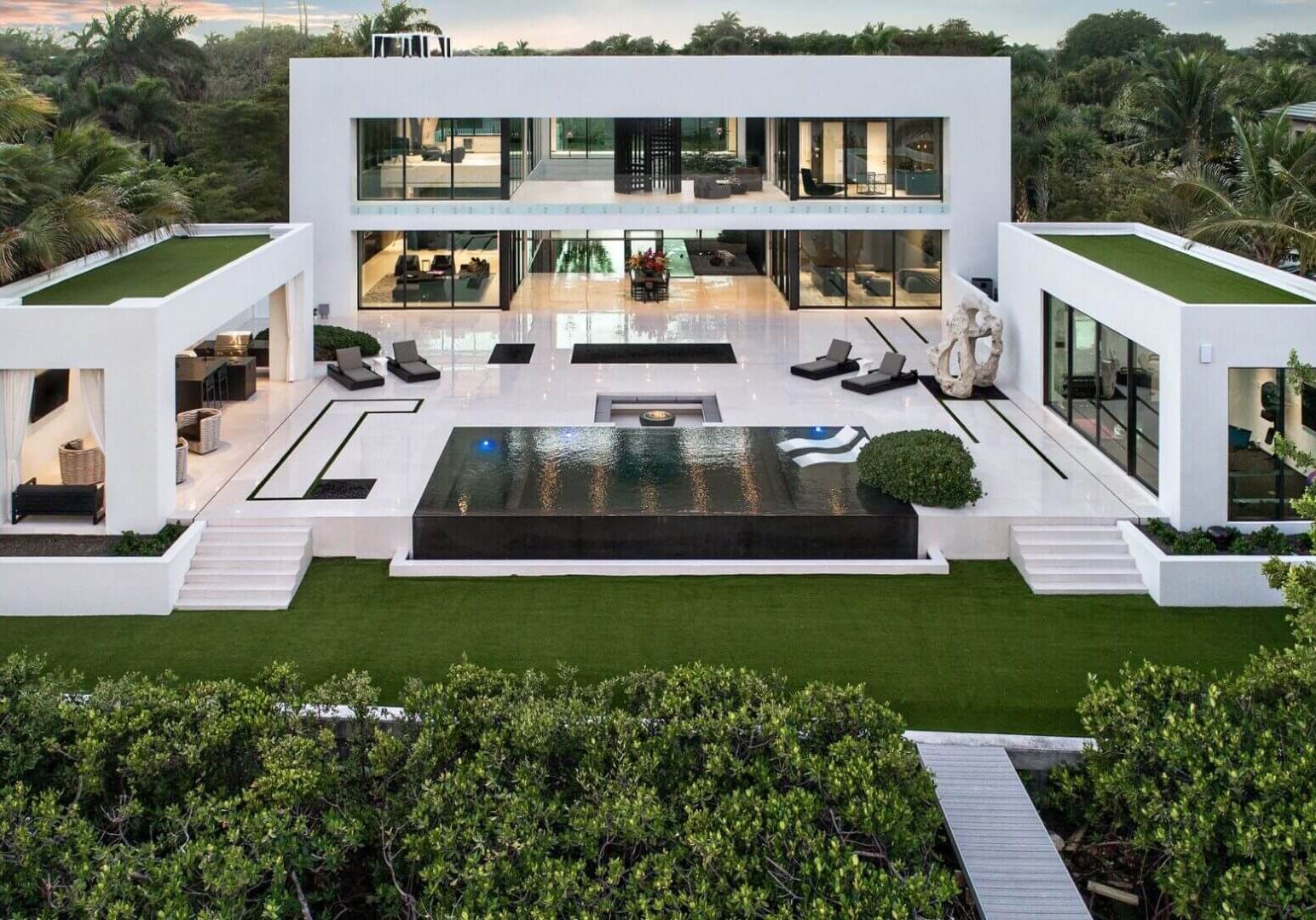 A large white house with a pool in the middle of it