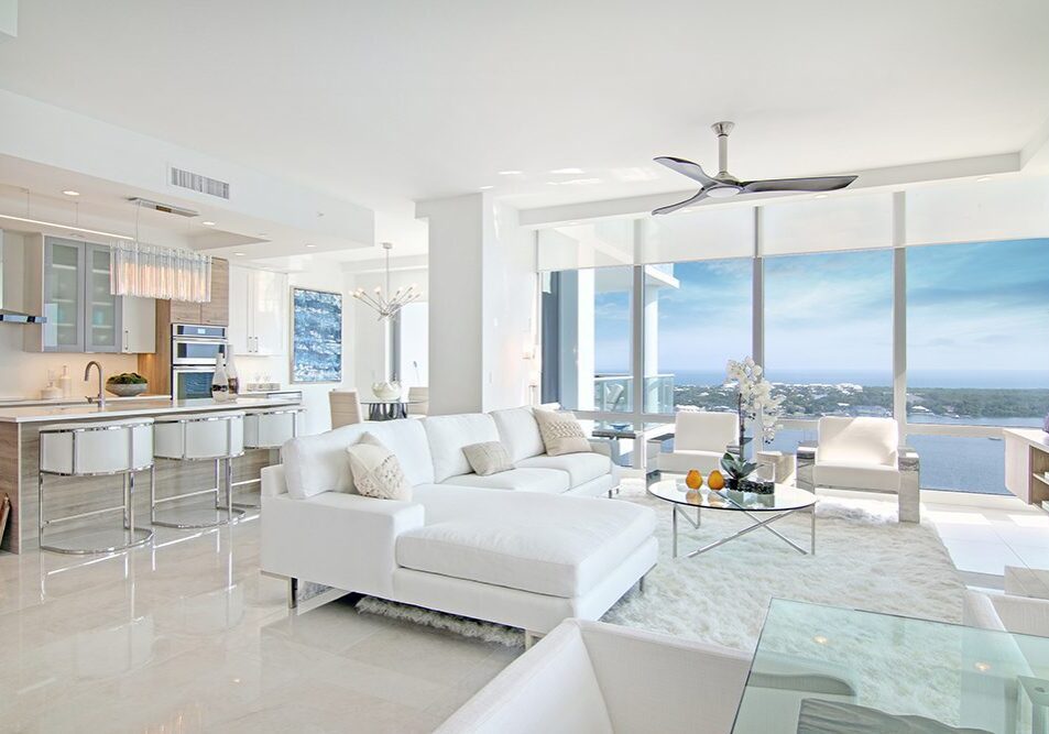 A living room filled with furniture and large windows.