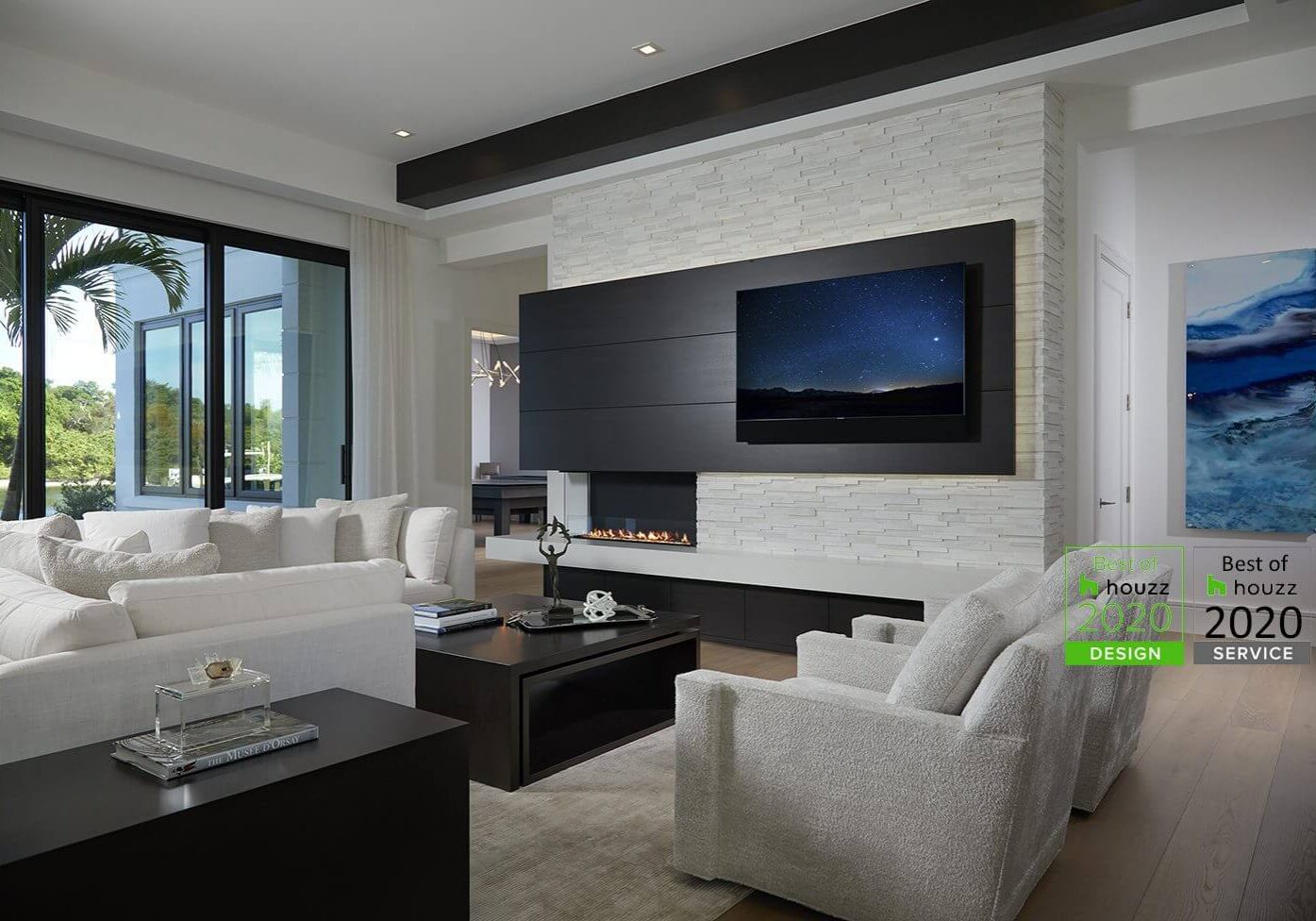 A living room with white furniture and a flat screen tv.