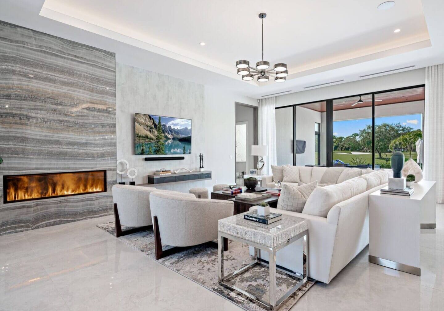 A living room with white furniture and a fireplace.
