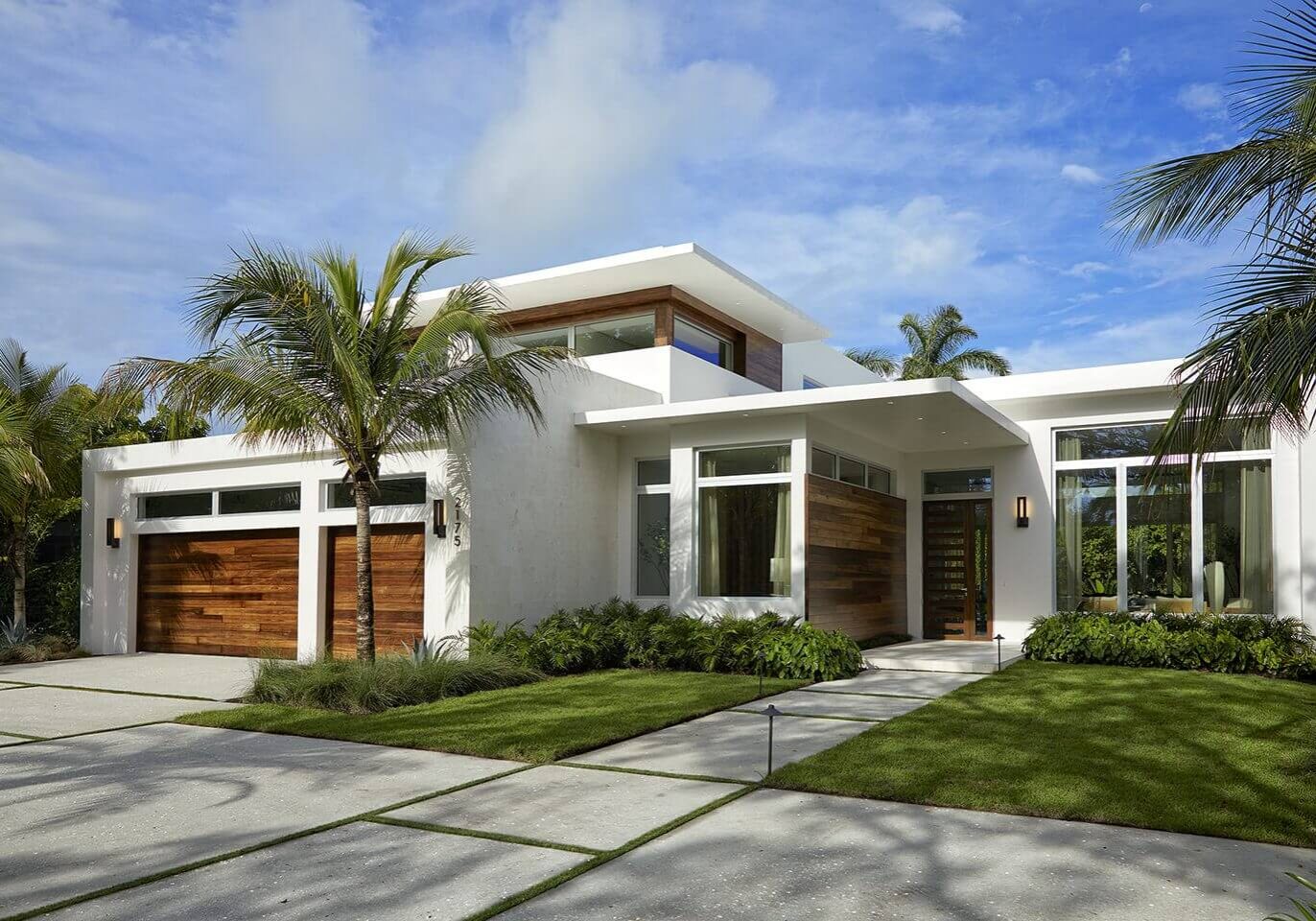 A white house with palm trees and grass