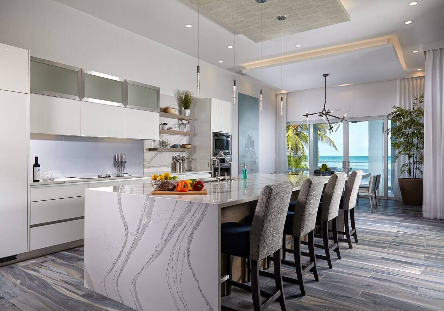 A kitchen with marble counter tops and white cabinets.