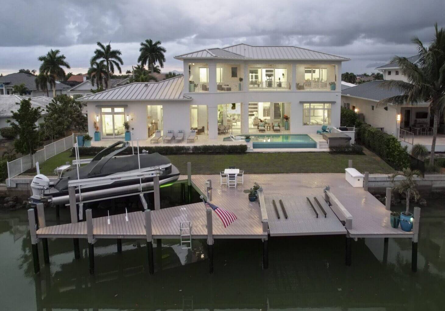 A large white house with a dock in the middle of it.