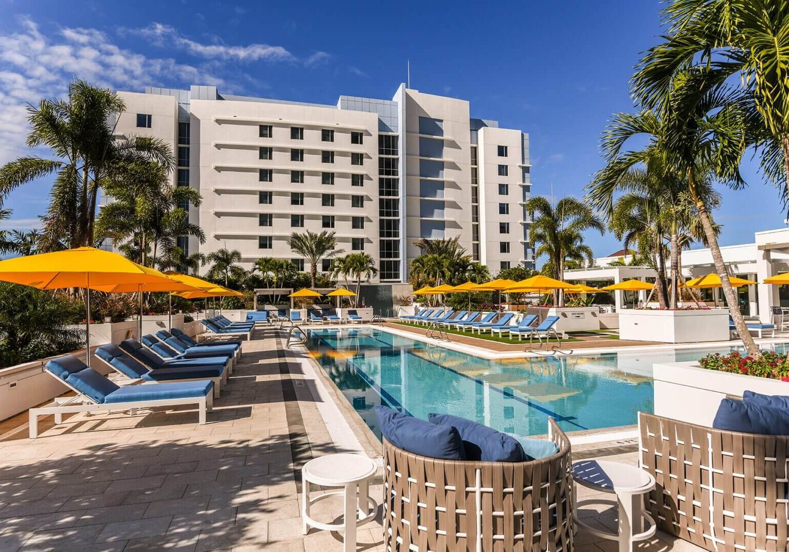 A pool with chairs and umbrellas next to it