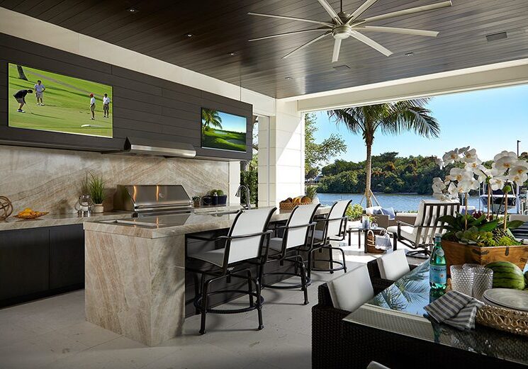 A large outdoor kitchen with an island and television.