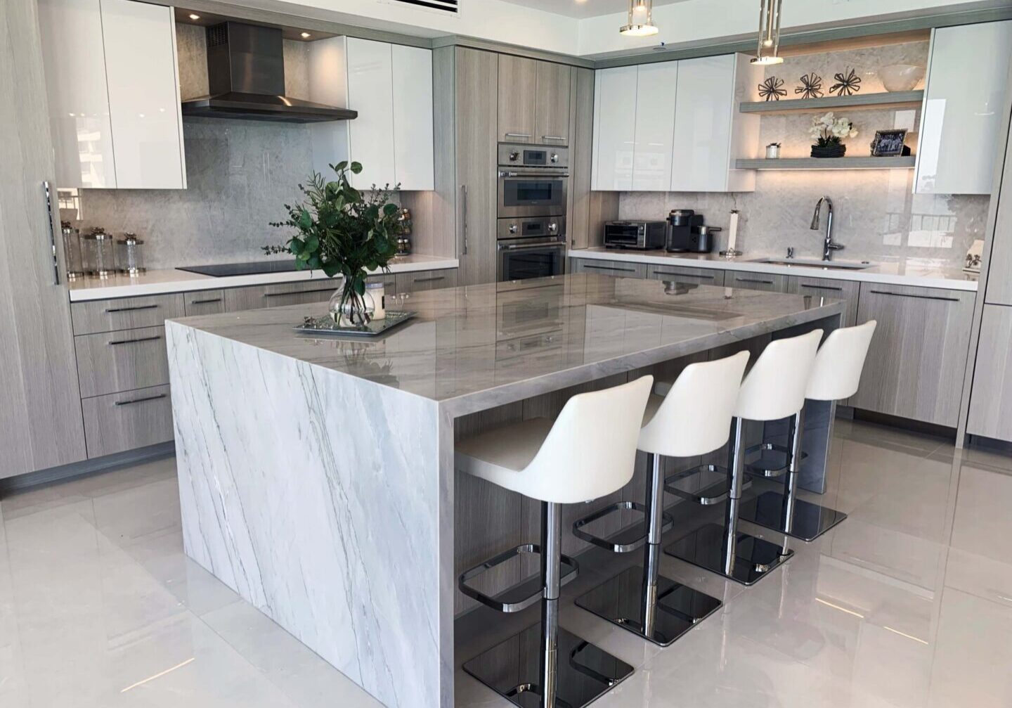 A kitchen with white cabinets and a large island.
