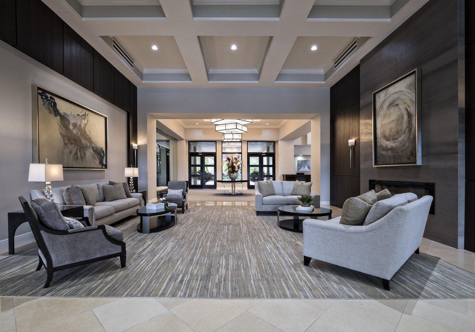 A lobby with couches, chairs and tables in it.