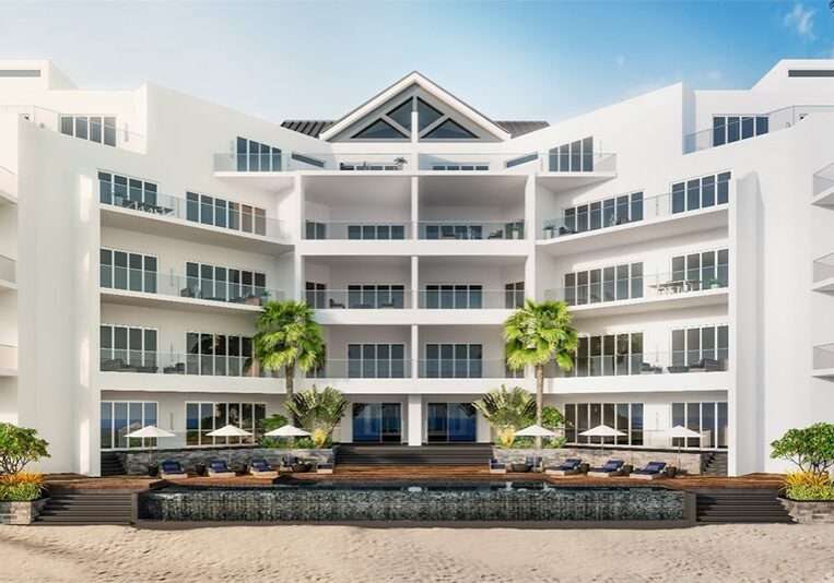 A large building with palm trees and blue chairs.